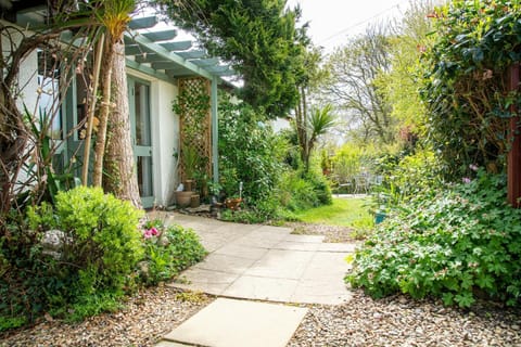 Front of the property with pathway and flower beds.