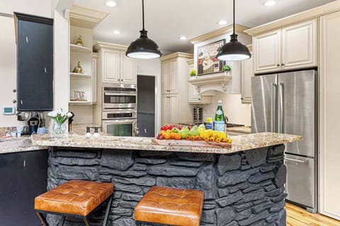A chef’s kitchen designed for gathering — complete with granite countertops, double ovens, and a stone island that doubles as the perfect spot for drinks or conversation.
