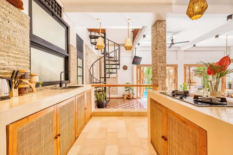 Warm and inviting kitchen space with rattan cabinets, modern accents, and seamless indoor-outdoor flow