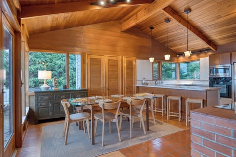 Open-concept dining and kitchen with pendant lighting and modern appliances.