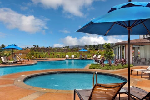 Relax and refresh in the community pool and hot tub, surrounded by lush tropical landscaping.