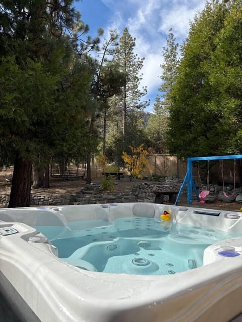 Peaceful outdoor space with a swing set, picnic area, and hot tub.