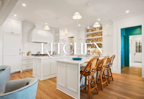 Open kitchen with island seating and modern pendant lighting.