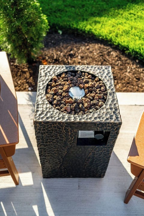 Back patio with two comfortable, Adirondack-style chairs and fire pit.