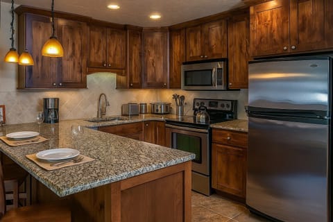 Full kitchen with crockpot, pot and pans, full dishware and dishwasher.
