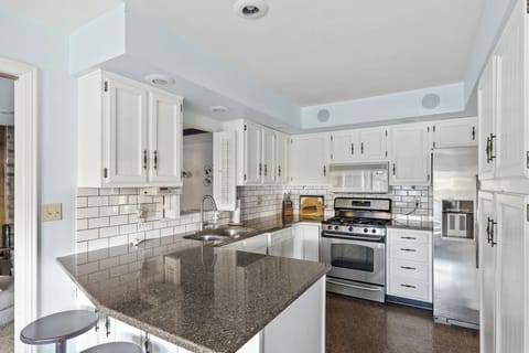 Willow on the Pond - Fully stocked modern kitchen with stainless steel appliances, stone countertops, and breakfast bar.