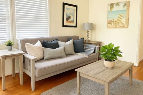 The spacious living room features a 55” Smart TV and a full-size futon, perfect for families or extra guests. A dedicated work desk provides a convenient space for remote work or planning your next adventure.