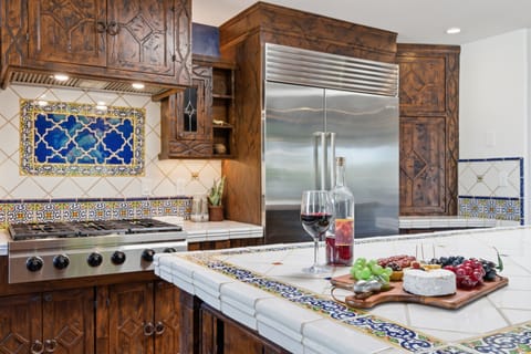 Fully equipped kitchen with stainless steel appliances, a sleek kitchen island, ample counter space, and a gas fireplace.