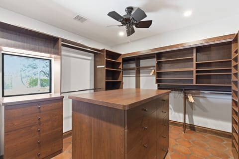 Primary bedroom with a King bed, smart TV, private access to outdoor patio, large walk-in closet, and walk-in shower.