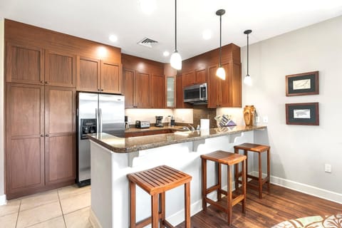 A breakfast bar that brings casual dining into your sleek kitchen, complete with rich cabinetry.