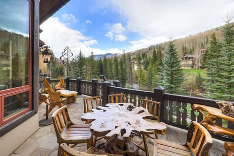 Mountain-view deck with rustic outdoor dining—perfect for post-ski meals or sunny morning coffee.