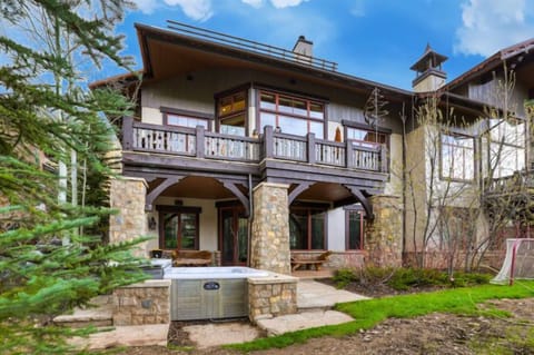 Welcome to your luxurious retreat, where an inviting hot tub awaits on the stone patio, perfectly positioned amidst the lush greenery for ultimate relaxation and privacy.