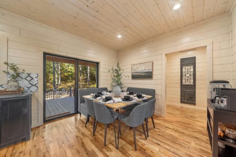 Intimate dining nook with cushioned bench seating and sliding doors that open directly to the forest view deck.