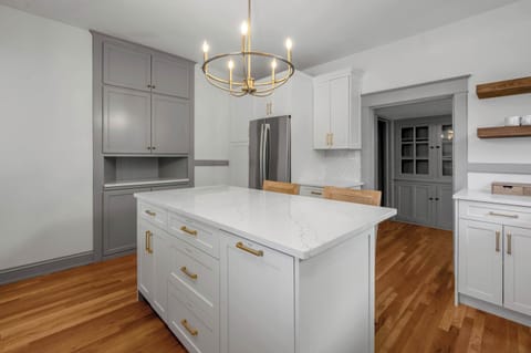 Refined and well-appointed kitchen with crisp white cabinetry, gold accents, and a generous island that makes meal prep and conversation a breeze.