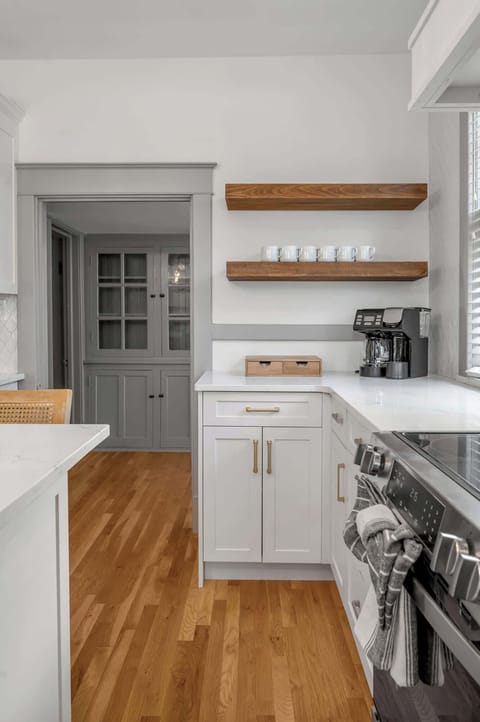 Luminous and refined culinary space boasts marble-style counters, striking hardware, and a comfortable island perfect for casual dining.