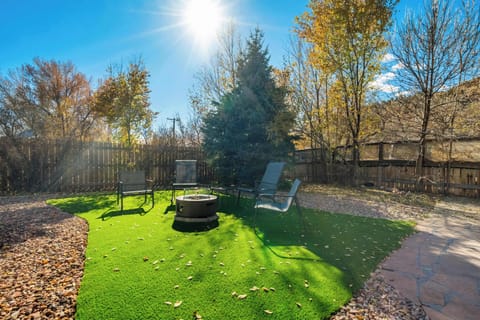The backyard features a sunny fire pit lounge with plenty of seating, creating an inviting place to hang out outdoors.