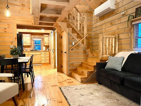 ✨ Imagine relaxing in this cozy log cabin living space—gather for meals, play games, or unwind after a day in Shipshewana. Your home away from home awaits! 🥰🪑