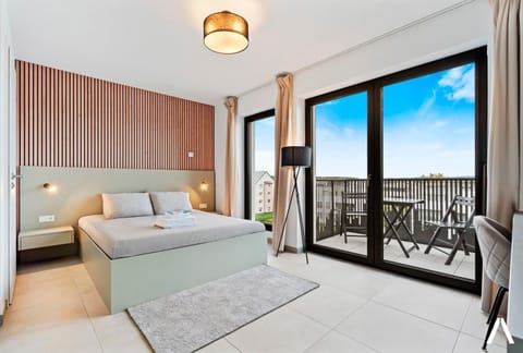 Cozy Living and Sleeping Area – Relax in a comfortable space with a plush queen-sized bed and elegant wooden accent wall.