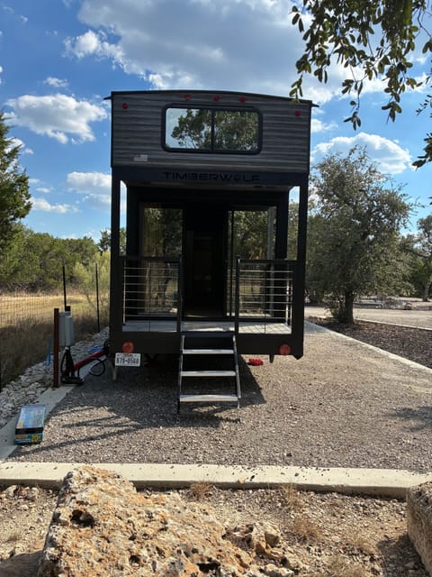 Private deck entry with m glass doors — surrounded by Hill Country oaks and open skies.