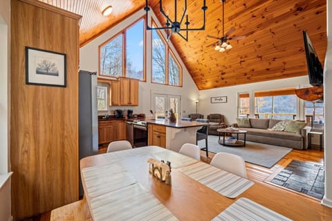 Open dining area next to the kitchen with vaulted ceiling and windows.