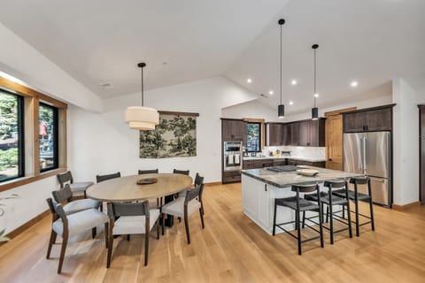 Custom round dining table with seating for ten adjacent to large open kitchen.