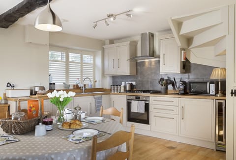 Open-plan well-equipped kitchen with dining table seating four guests