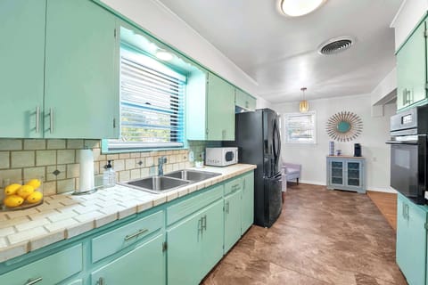 cozy kitchen with tile counters and backsplash make cleanup a breeze