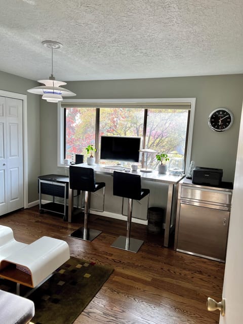 Upstairs office featuring a day bed, two office chairs, and a large WFH area