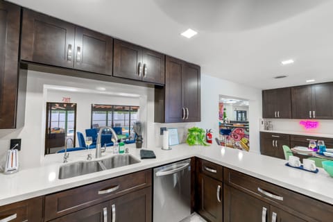 COOK TOGETHER FAMILY FUN! Fully-equipped kitchen with modern appliances with a pass-through window, overlooking the pool . Perfect for families who love homemade meals. #Familyfriendlyairbnb #Largehomeairbnb