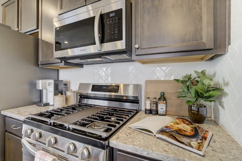 The kitchen features sleek, new appliances and everything needed for everyday meals.