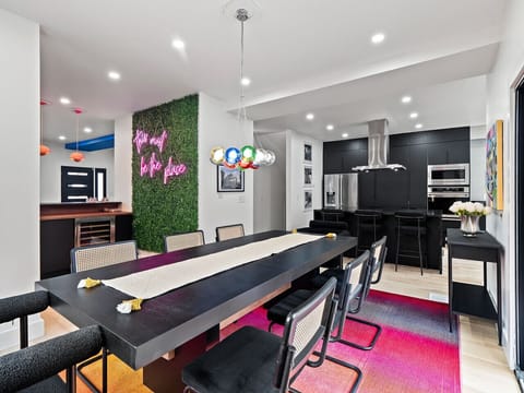 Spacious kitchen-dining layout w/ playful lighting & modern details.