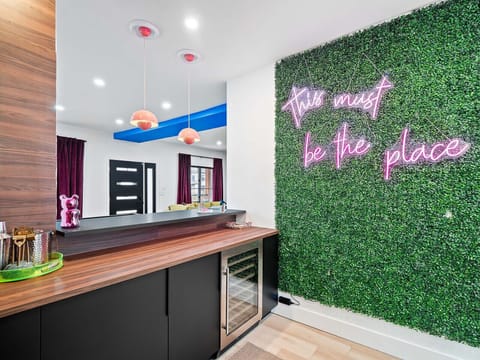 Outdoor-inspired bar nook w/ green wall & warm lighting for chill moments.
