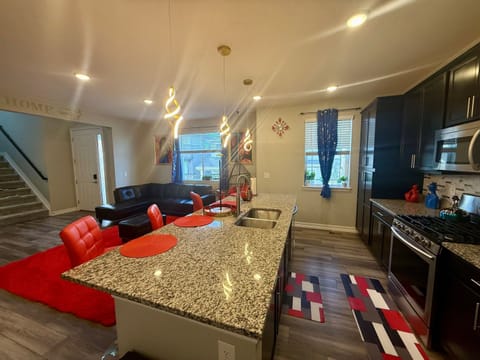 Functional kitchen & living area together. The island with bar stools gives lots of space for cooking and serving. Cozy seating & large windows make it a relaxing spot to cook, eat, & hang out