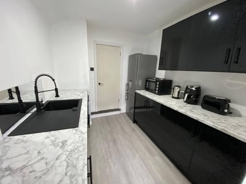 Sleek kitchen with glossy black units and marble-effect worktops