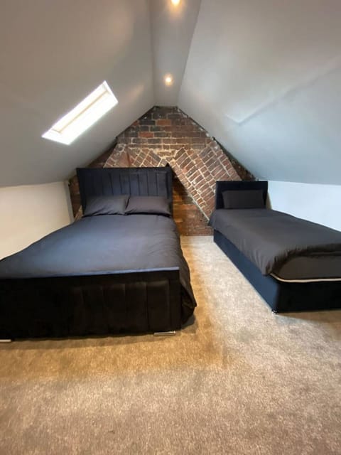 Attic bedroom with super-king and single bed beneath a skylight