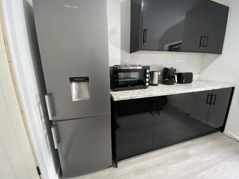 Kitchen area with fridge, microwave, and appliances