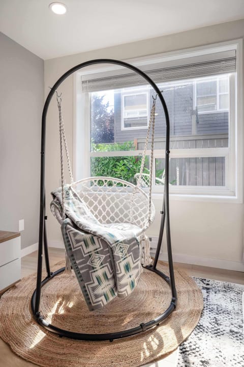Bright living space with a hanging chair, perfect for relaxing in natural light.