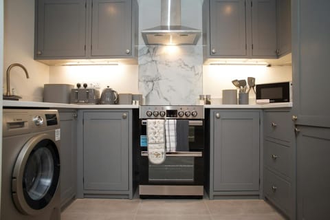 Kitchen with washing machine, hob, oven, extractor hood