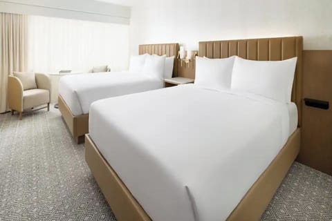 Settle into crisp double-queen comfort beside soft natural light.