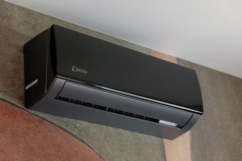 The air conditioner set against the multicolored wall keeps the temperature pleasant all year round, ensuring guests can relax in total comfort.