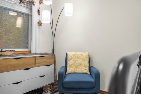 Corner of a bedroom with a blue accent chair.