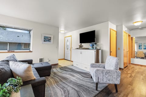 Living area view featuring a television mounted above a white cabinet and nautical decor.