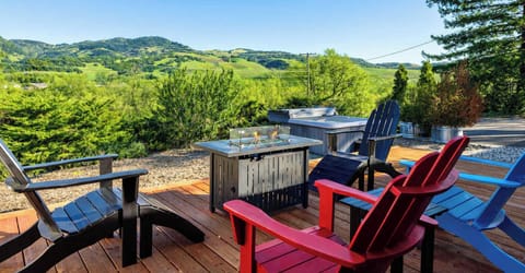 Unwind on the scenic deck with cozy chairs, fire table, and sweeping valley views—ideal for coffee at sunrise or relaxed evenings outdoors.