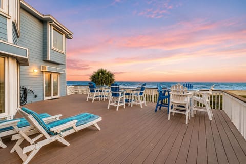 Beachfront deck with lounge chairs, outdoor dining table, and panoramic Gulf views at Life's A Beach in Galveston, TX. Spacious oceanfront patio perfect for sunrise coffee and sunset gatherings.