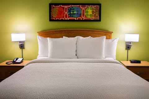 Drift off in a plush bed with warm bedside lighting.