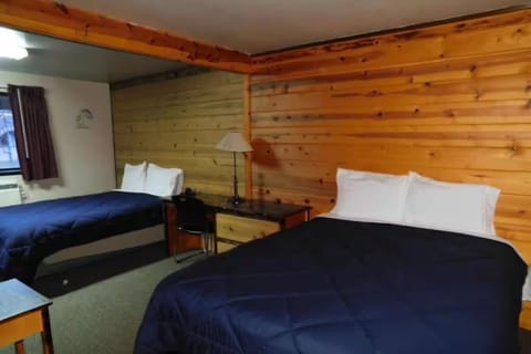 Settle in comfortably with two beds and rustic wood walls.