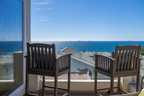 Two bar-height chairs positioned for relaxing and taking in the beautiful Pacific views.