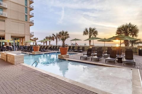 Unwind at sunset beside the oceanfront pool and loungers.