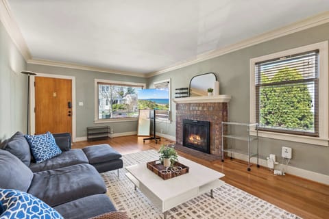 Curl up by the fireplace for a cozy movie night in a bright, sun-drenched living space.