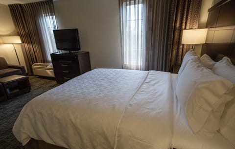 Relax in this cozy studio suite, featuring soft bedding, warm lighting, and inviting views from the large windows.
